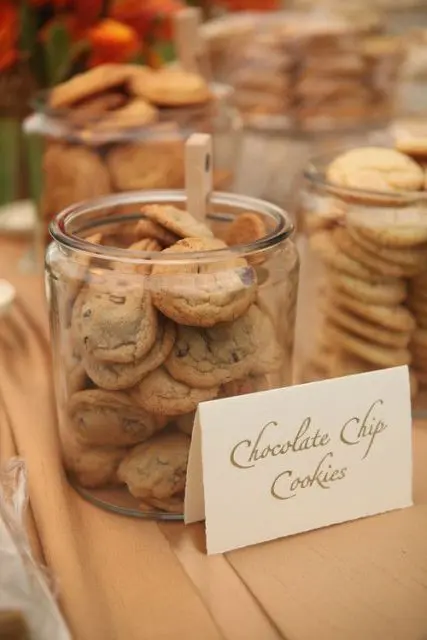 a cookie bar with large jars filled with cookies plus tongs to grab the sweets comfortably