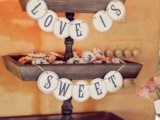 a rustic wooden cookie stand with banners can serve a lot of  pies, cookies and other sweets