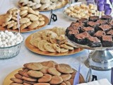 a simple cookie table with metallic plates with cookies, sweets and cake pops to please everyone