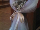 white tulle plus wildflowers and a silk bow to decorate the wedding aisle