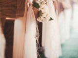 white tulle bench decor with baskets filled with baby’s breath, white blooms and greenery
