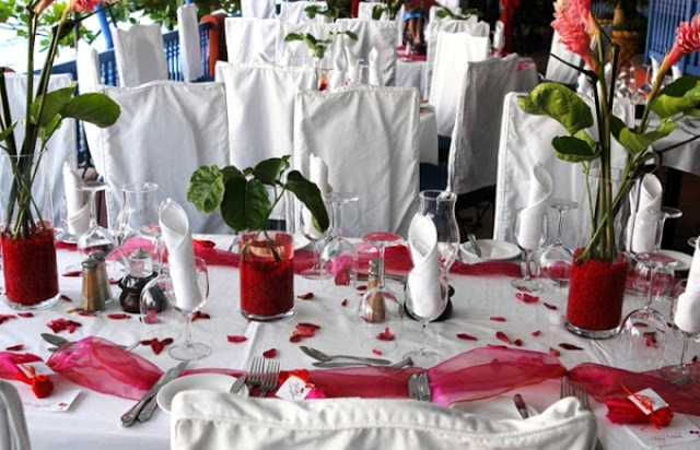 Red tulle table runners and red wedding centerpieces make the decor bolder
