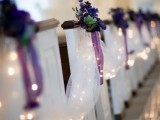 white tulle garlands with LEDs, purple blooms with greenery and purple bows