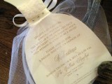 an invitation to a bridal shower shaped as a wedding dress with tulle covering it