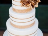 a gold lace and white striped wedding cake with gold sugar roses is a lovely idea for a modern wedding with a touch of glam and romance