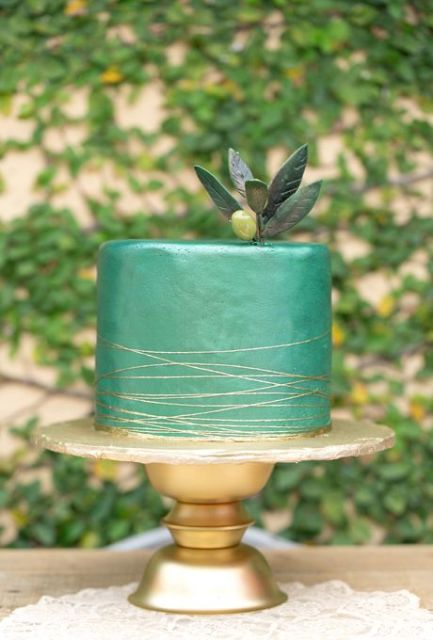 a green wedding cake with gold stripes, sugar leaves and an olive on top for a modern Italian wedding