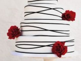 a striped black and white wedding cake decorated with burgundy blooms for a bold and cool touch is a lovely idea for a modern wedding