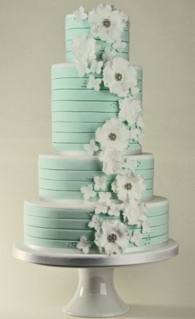 a mint green striped wedding cake decorated with white sugar blooms is a stylish idea for a spring or summer wedding