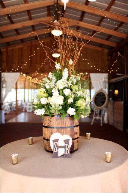 wine barrels as vases for floral arrangements and candles around is a lovely idea for a vineyard or a rustic wedding