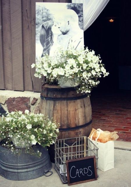 lovely rustic wedding decor with a barrel and a metal piece, floral arrangements, a wire basket and some bread is cool
