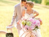 a white bike with a chalkboard sign, a basket filled with pastel blooms is a chic decor idea for your wedding