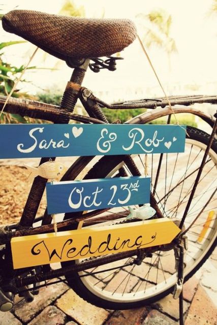 a bike with some signs hanging is a lovely decoration for a relaxed and fun wedding, with a rustic feel