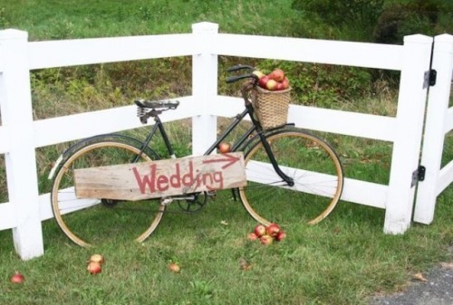 a bike with a basket filled with apples and a wooden plaque is a lovely rustic decoration you may rock