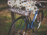 a blue bike decorated with chamomiles, a wooden sign is a pretty and cool idea for a rustic wedding