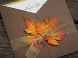 a wedding invitation in a cardboard envelope and a bold fall leaf will help you embrace the season and hint on the theme