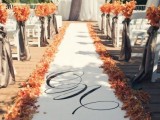 a romantic wedding ceremony space done with curtains, a runner, bold fall leaves and fall leaf arrangements is a lovely space