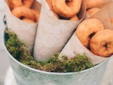 a bucket with moss and kraft paper cones with donuts is a cool rustic idea for a wedding