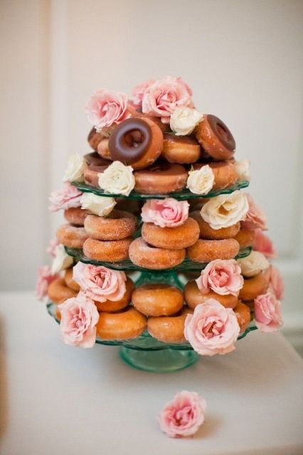 a donut tower with fresh blooms in pink and white is a cute casual substitute for a traditional wedding cake