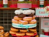 a simple and cute stand with lots of glazed donuts, moss, a fun topper with a banner for a casual wedding