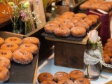 trays with donuts on stands, blooms in vases for a rustic and relaxed donut bar at the wedding