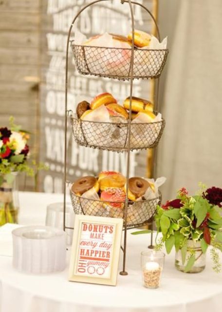 a simple wire stand with lots of glazed donuts and a sign for a rustic or laid-back wedding