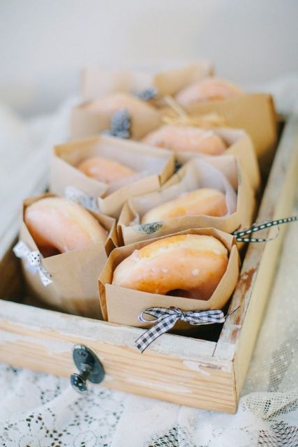 a box with glazed donuts in individual packs is a cool idea to serve them as wedding favors or just late night snacks