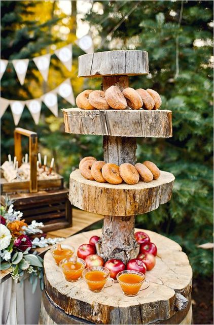 a rustic stand with thick wood slice tiers and a thick branch for a woodland, backyard or rustic wedding
