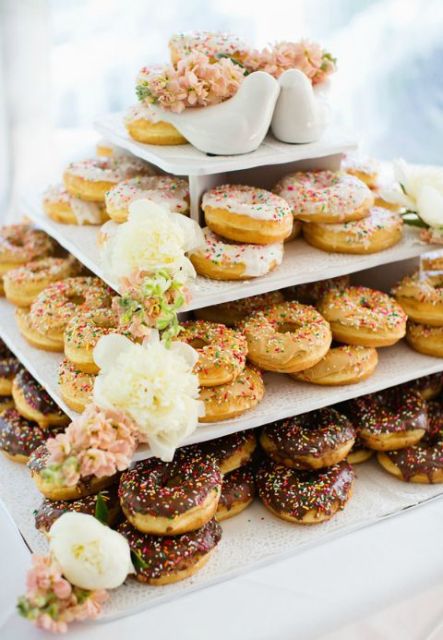 a multi-tier square stand with glazed donuts, blooms and a cute pigeon topper for a romantic feel
