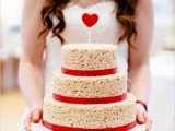 a krispie rice wedding designed as a usual one, decorated with red ribbons and a red heart topper