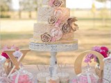 a krispie rice wedding cake with gold ribbons and gold and pink sugar flowers