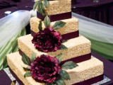 a square krispie rice wedding cake with purple ribbons and large purple blooms with greenery is a chic idea