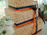 a square krispie rice wedding cake with navy and orange ribbons is a stylish and bold idea