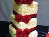 a square krispie rice wedding cake with red ribbons, red blooms looks refined
