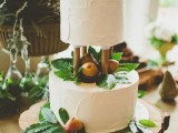 a white wedding cake with foliage and pears and candied pears is a gorgeous idea for a modern fall wedding
