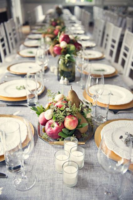 a vegetable wedding centerpiece of a tray with apples, pears, greenery and candles in glasses is a lovely idea for a rustic fall wedding