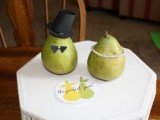 a whiet hexagon wedding cake topped with a couple of pears that portray the couple is a cute and fun idea for a fall wedding