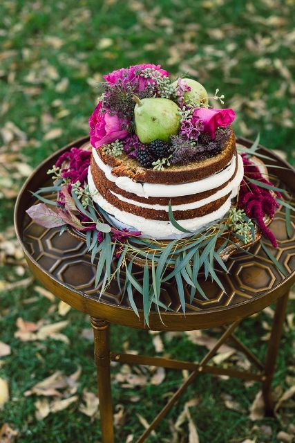a naked wedding cake topped with bold blooms, some wildflowers and pears is a gorgeous idea for a fall boho wedding
