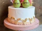 an elegant white wedding cake with gold touches, bold pink blooms and personalized pear cake toppers is a super fun and cool idea