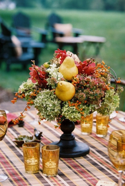 a unique and bold fall wedding centerpiece of burgundy and green blooms, berries, twigs and a couple of pears is a lovely idea for the fall