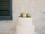 a white wedding cake topped with greenery and pears is a lovely idea for a modern fall wedding, it’s simple and pretty