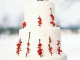 a white snowy wedding cake decorated with berries on twigs is a stylish idea for a winter boho or rustic wedding
