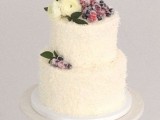 a snowy winter wedding cake topped with leaves, white blooms and sugared berries and fruits is a stylish idea