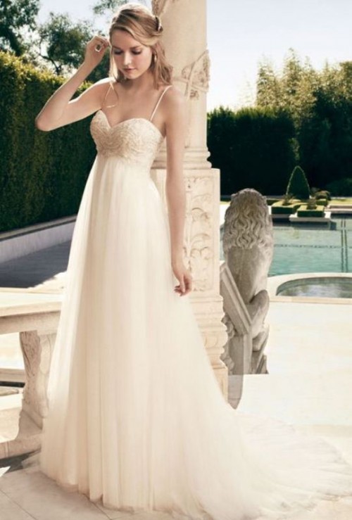 an empire waist wedding dress with an embroidered bodice, spaghetti straps and a pleated skirt with a train