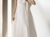 a refined A-line wedding dress with an illusion lace neckline, an empire wiast and a pleated skirt
