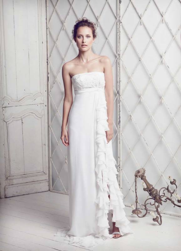 a strapless empire waist fitting wedding gown with a side slit with ruffles and a draped bodice for a sexy look