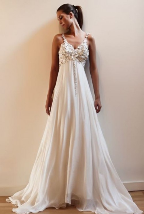 a statement empire waist wedding dress with a floral applique bodice, a pleated skirt and embellished straps
