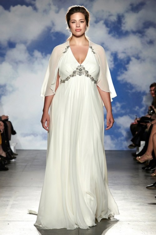 a plus size A-line wedding dress with an embellished bodice, a pleated skirt and a capelet