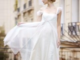 a romantic A-line wedding dress with an empire waist, cap sleeves, draped layered skirt with polka dots