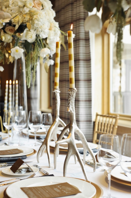 Antlers as candleholders and striped candles to decorate a winter wedding table