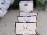 moss, a branch and some cards with antlers look cool and woodland-like and bring that cozy feel to your wedding